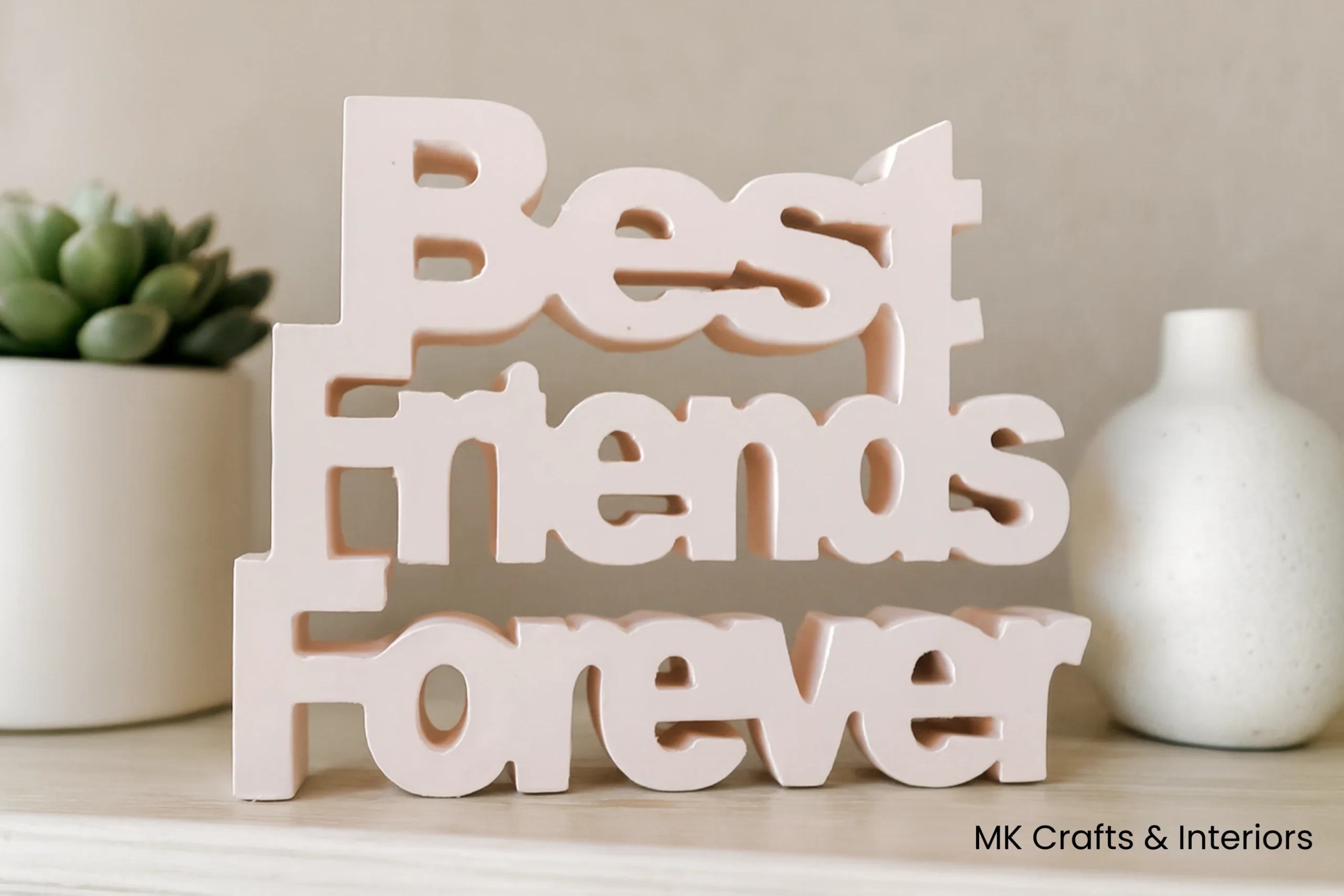 Light Peach wooden “Best Friends Forever” decorative showpiece by MK Crafts placed on a shelf with plants and candles – handcrafted friendship gift décor.