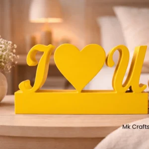 Yellow “I Love U” wooden decorative showpiece by MK Crafts & Interiors in Hyderabad placed on bedside table – cheerful romantic gift.