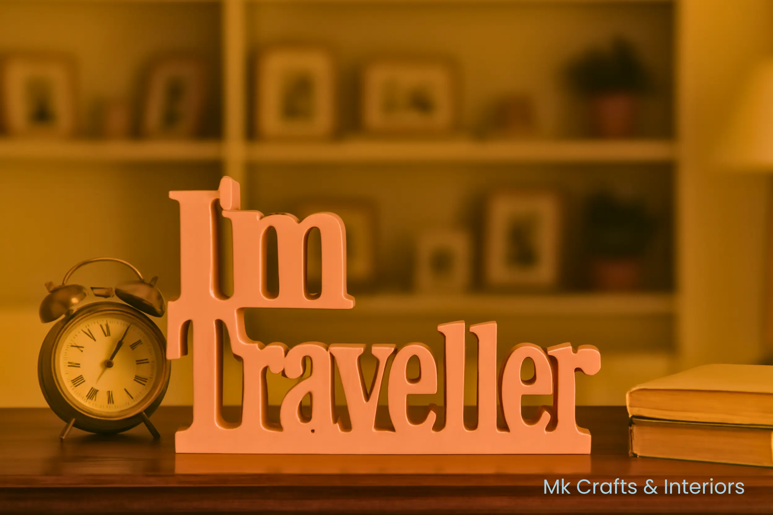 Light pink “I’m Traveller” wooden decorative showpiece by MK Crafts & Interiors Hyderabad displayed on table.